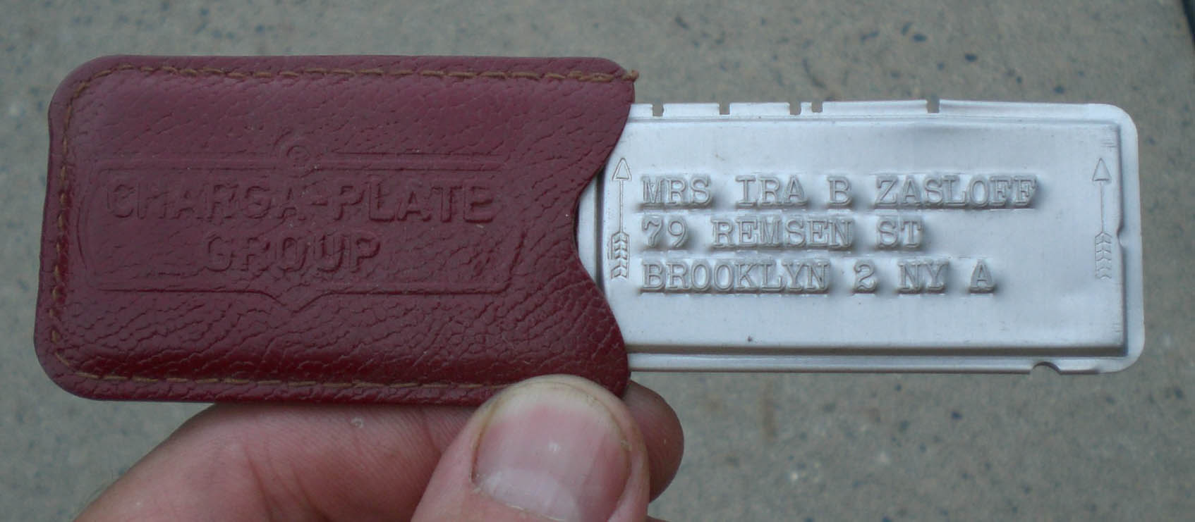 A vintage metal charge plate from a department store.